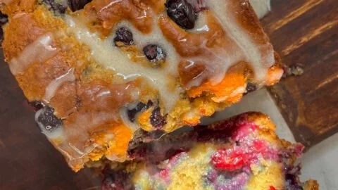 Loaf of homemade blueberry banana bread with fresh blueberries